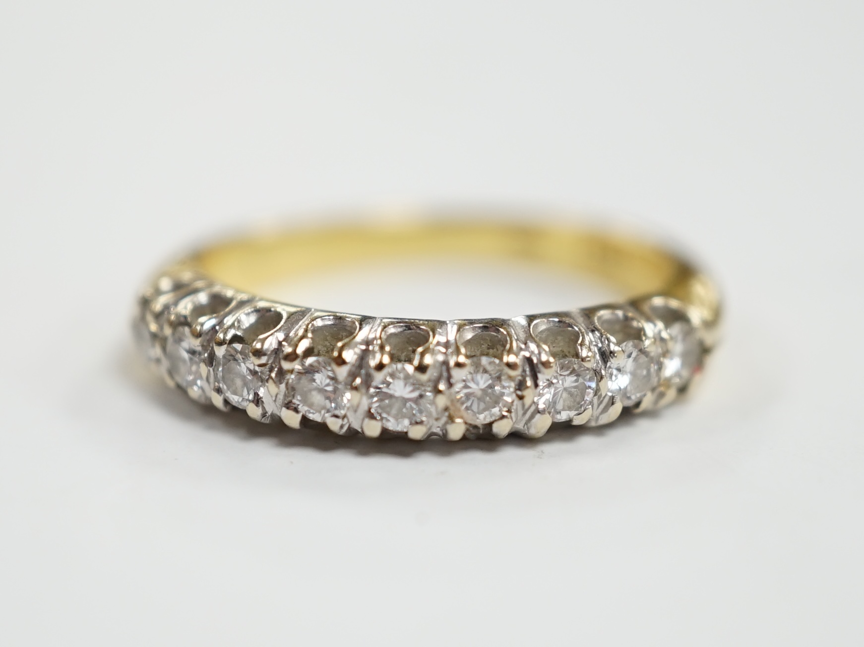 A modern 750 yellow metal and nine stone diamond chip set half hoop ring, size I/J, gross weight 3.1 grams.